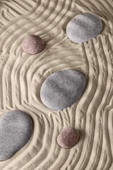 Smooth lines on the sand and round stones in the rock garden, for relaxation and spiritual harmony