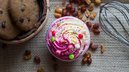 Cupcakes with cute colourful tiny topping in different shapes and Chocolate chips cookies on the black background, text and copy space available.
