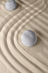 Fototapeta na wymiar Smooth lines on the sand and round stones in the rock garden, for relaxation and spiritual harmony
