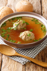 Liver Dumplings are a traditional Bavarian dish severd in a hot brooth close-up in a plate on the table. Vertical
