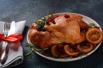 Roasted/baked whole chicken with spices, orange and herbs. Christmas food concept.