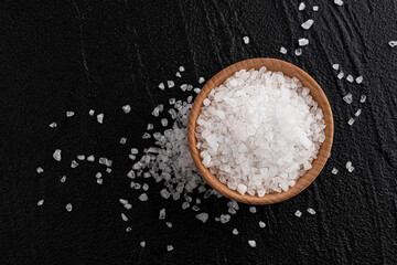 Pile of sea salt on black background, top view