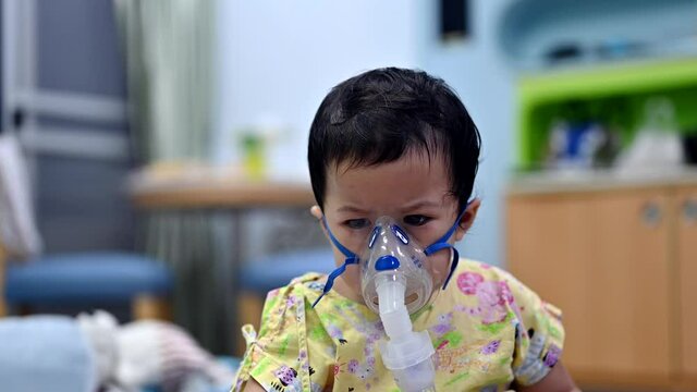 Asian baby was sick as Respiratory Syncytial Virus (RSV) in kid hospital. Thai little girl having inhaler containing medicine for stop coughing and disease flu.