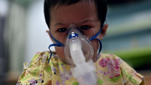 Asian baby was sick as Respiratory Syncytial Virus (RSV) in kid hospital. Thai little girl having inhaler containing medicine for stop coughing and disease flu.
