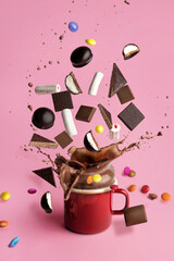 Hot chocolate ingredients liquid splash explosion on pastel pink background. Sweets and cocoa...