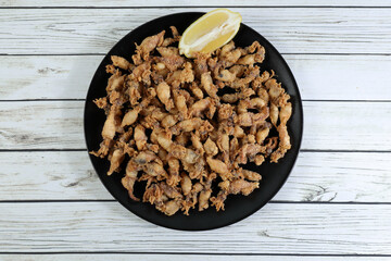 Ration of grilled baby corn on wooden table