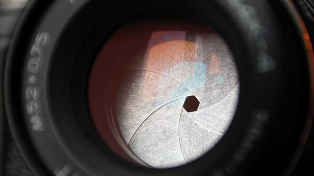 Diaphragm blades of the fixed lens opening and closing aperture f-stop adjustment of a photo camera close-up shot with HUD animation