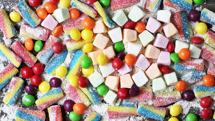 delicious marmalade of different colors on a wooden background, top view