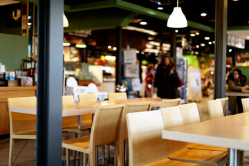 View of wooden tables and chairs in a motorway cafe self service restaurant - obrazy, fototapety, plakaty