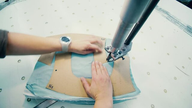 Fabric is getting cut into patterns with a slicing mechanism