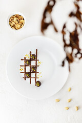 Homemade chocolates with nuts in a plate. Vertical orientation, top view.