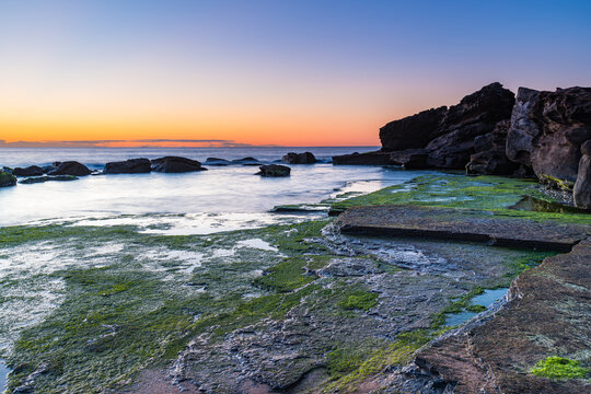 Sunrise by the Sea and Rocks on the Shoreline