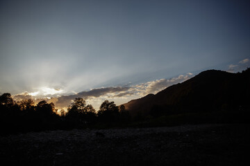 silhouette shot image of mountain and sunset sky in background.