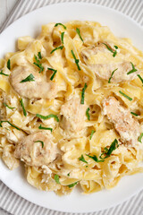 Homemade Chicken Fettuccine Alfredo in a plate on a white wooden table, top view. Flat lay, overhead, from above. Close-up.
