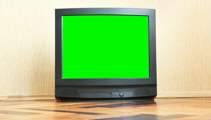 Antique TV with green screen on an antique wooden cabinet, old design in a house in the style of the 1980s and 1990s.Interior in the style of the USSR.