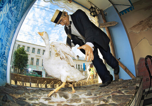 Kostroma, Russia. Panikovsky catching goose, a scene from the Soviet comedy film "The Little Golden Calf" based on eponymous novel by Ilf and Petrov. Photo taken with fish-eye lens in the city's cafe.