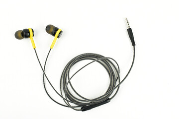 Obraz premium Black and yellow color earphone on white background, top view 