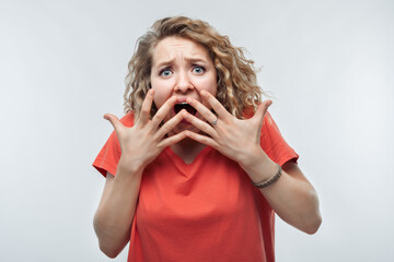 Image of scared blonde girl covering her mouth with hands. Fright, phobia and facial expression...