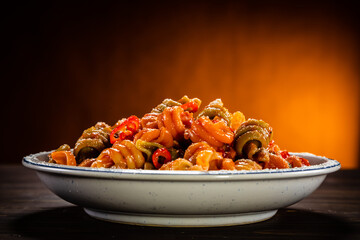 Pasta with tomato sauce, meat and parmesan on wooden table