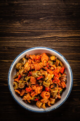 Pasta with tomato sauce, meat and parmesan on wooden table