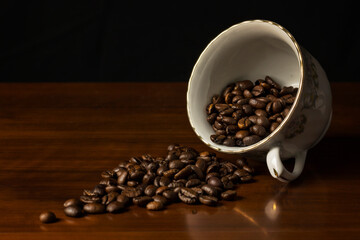 White cup full of coffee beans on wooden table