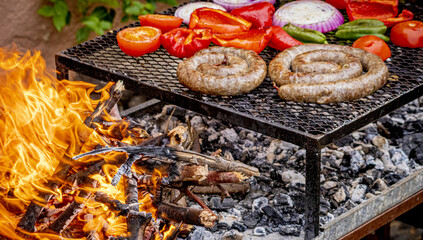 Barbacoa de salchicha casera, pimientos, cebollas y tomate, con fuego de leña.