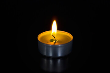 Detail of burning green candle on black background