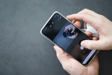 Сleaning concept. Wipe dirt off surfaces. Disinfectant treatment of phone screenl. Sanitary treatment at home quarantine.