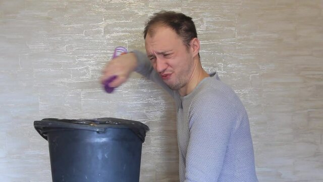 Crazy guy disinfects the trash bin with toilet water.