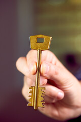  Close up of human hand holding golden key