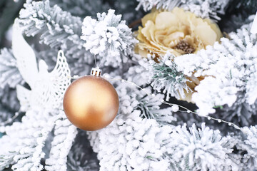 Fototapeta na wymiar Christmas holiday background. Silver and color bauble hanging from a decorated on tree with bokeh and snow, copy space.
