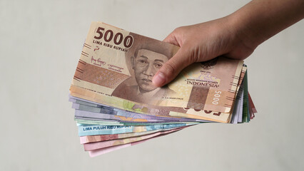 Indonesian rupiah currency, is held by women's hands