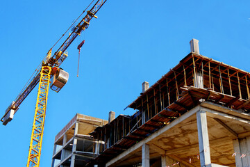 Construcrion site background. Concrete building under construction. Big tower crane. Industrial background.