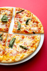 Classic cheese pizza over colourful red background with copy space. Fast food.