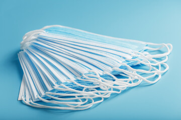 Medical protective masks on a blue background are stacked.
