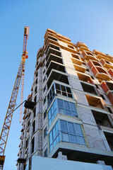 Construction site background. Hoisting crane and new multi-storey building