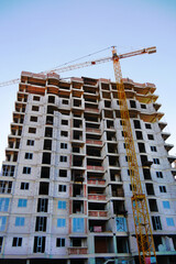 Fototapeta premium Skyscraper construction. Crane near building. Construction site background.