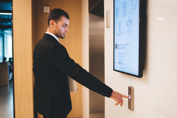 Businessman calling elevator in hallway © BullRun
