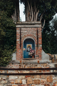 Old brick tabernacle in the streets of Florence picturing an iconic Madonna Fiorentina