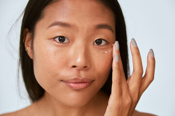 Woman applying under eye corrector
