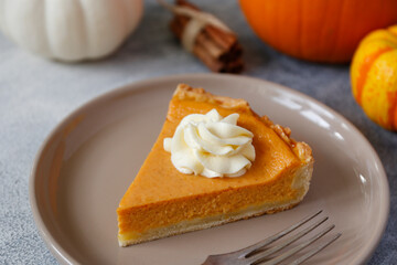 Traditional thanksgiving food on wooden table. Orange delicious homemade pumpkin pie with crust and decorative items. Thanksgiving table setting concept.Top view, close up, copy space, background.