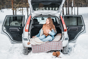 beautiful girl on the car in the winter
