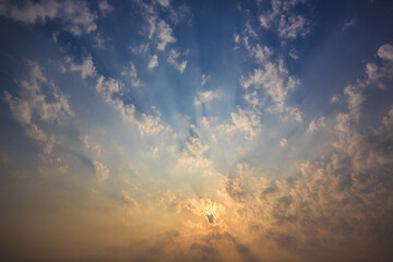 The sky is covered with clouds and the sun's rays penetrate