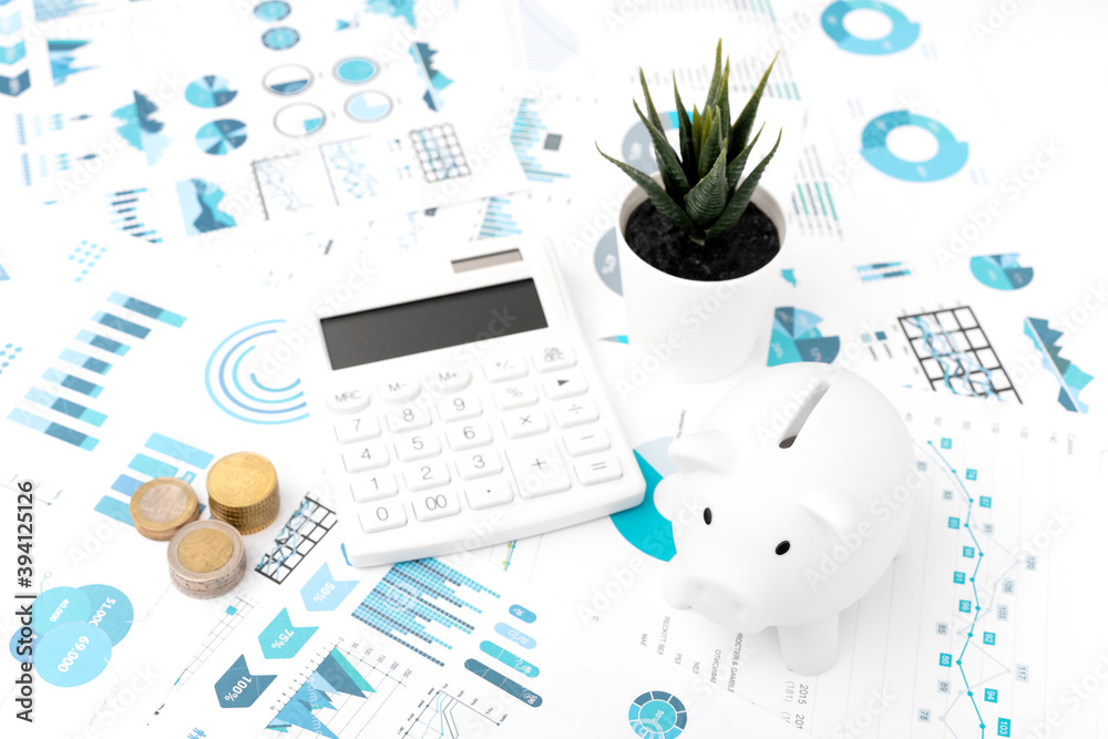 Wall mural Accounting concept. Piggy bank, calculator, graph, coins on white background. Top view.