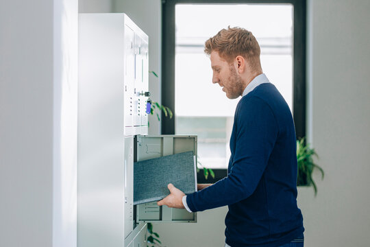 Businessman Putting Folder in Locker