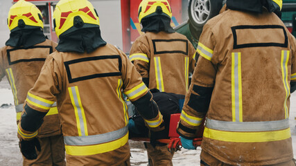 Firefighters carying injured person. Fire drill. High quality photo