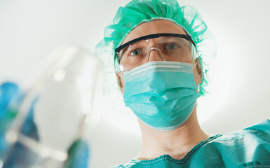 Male anesthesiologist giving gas mask to patient.