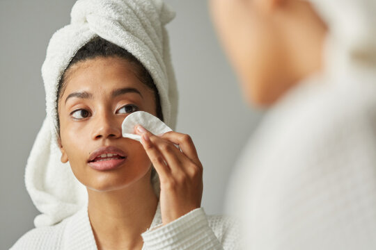 Girl using cleansing lotion close up