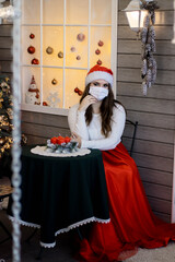 new year 2021 holiday virus protection girl in a mask and Santa Claus costume new year's meeting