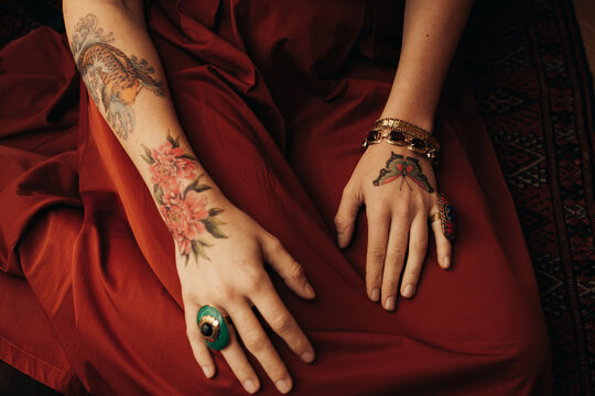 Woman's Hands Covered In Colorful Tattoos And Jewelry